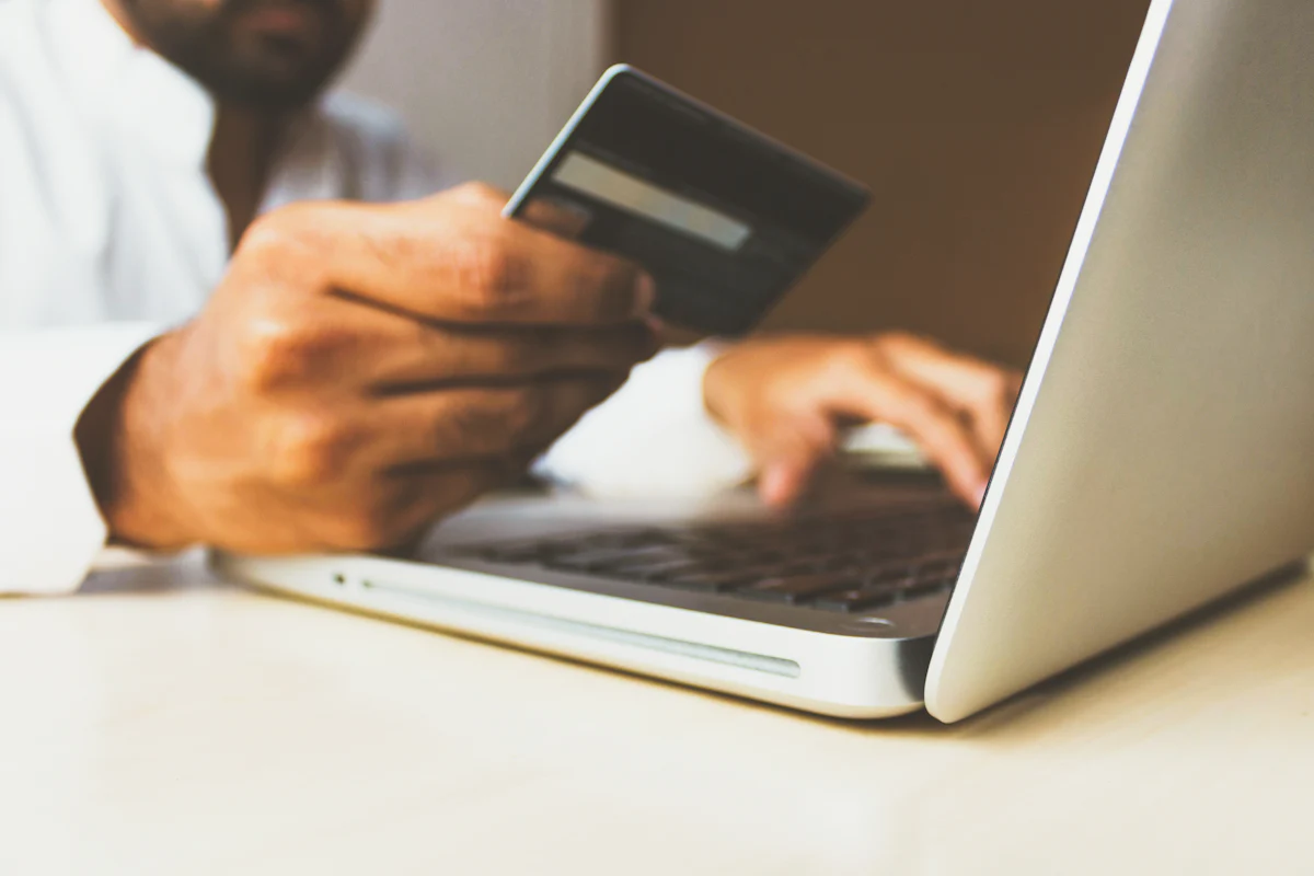 Shopper paying online with a card on a laptop