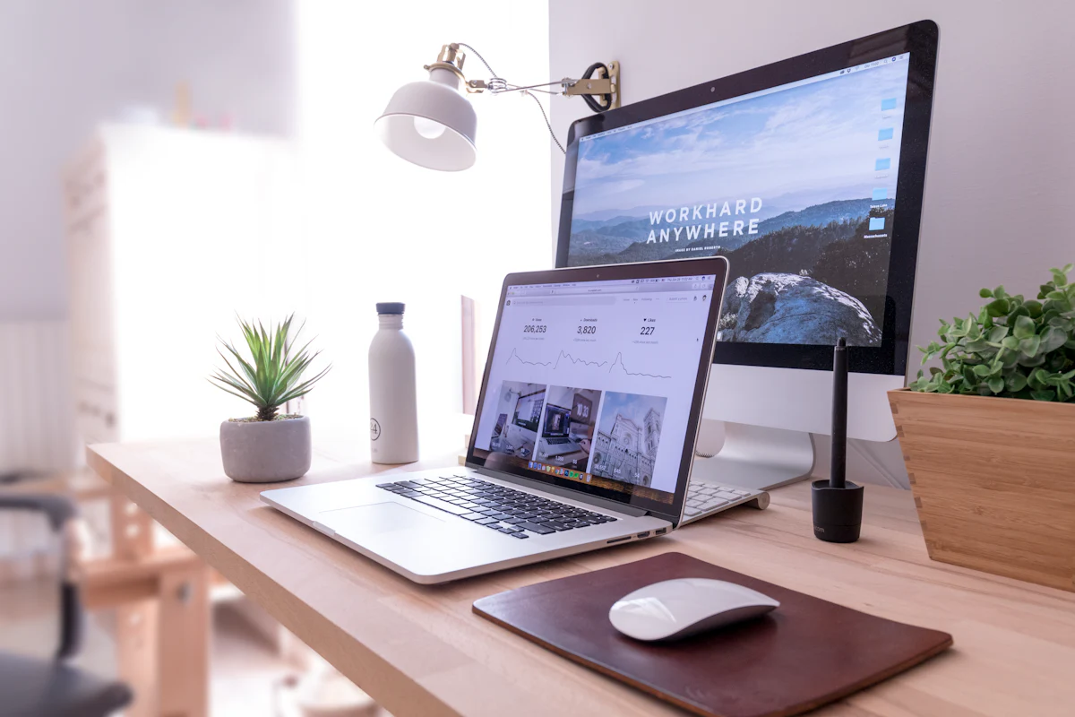 Laptop and desktop screen showing a website on a bright desk